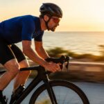 Cycliste sur velo de route en pleine sortie au coucher de soleil bord de mer