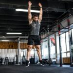 Sportif executant un burpee dans une salle de musculation moderne