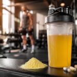 Shaker de BCAA jaune, poudre et gelules sur un banc de musculation