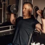 Homme faisant un développé haltères assis pour muscler ses épaules
