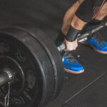 Homme réalisant un soulevé de terre avec une barre chargée en salle de musculation
