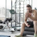 Sportif en pleine récupération après une séance de musculation intense en salle