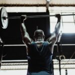 Homme ectomorphe en salle de musculation soulevant une barre pour prendre de la masse