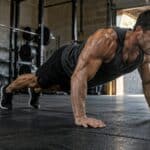 Homme realisant un burpee dans un garage-gym