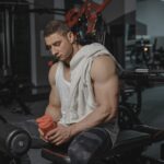 Sportif en salle de musculation tenant un shaker de proteines
