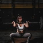 Hip thrust : femme pratiquant la musculation avec une barre dans une salle