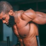 Homme realisant des dips triceps lestes dans une salle de musculation